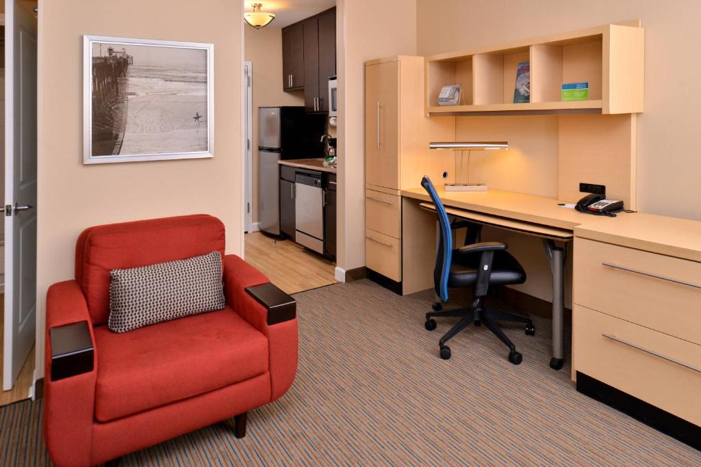 un bureau avec une chaise rouge et un bureau dans l'établissement TownePlace Suites Wilmington Wrightsville Beach, à Wilmington