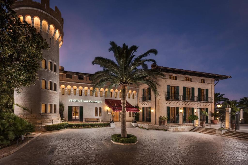 ein Gebäude mit einer Palme davor in der Unterkunft Castillo Hotel Son Vida, a Luxury Collection Hotel, Mallorca - Adults Only in Palma de Mallorca