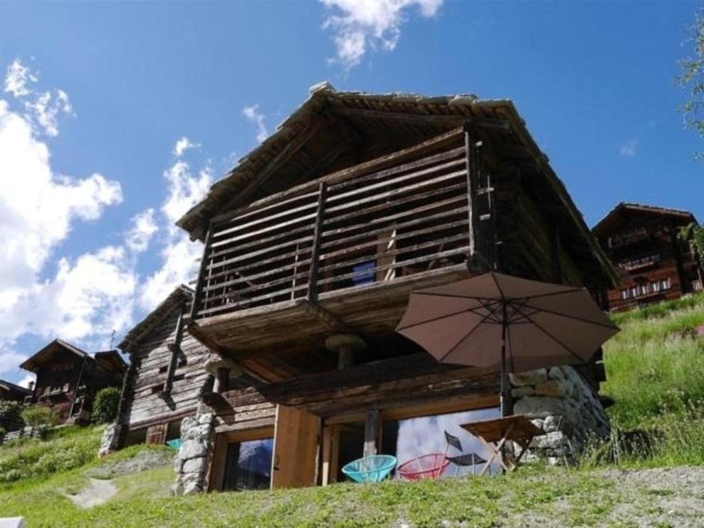 a house with an umbrella in front of it at Mayen à Olivier in Haudères