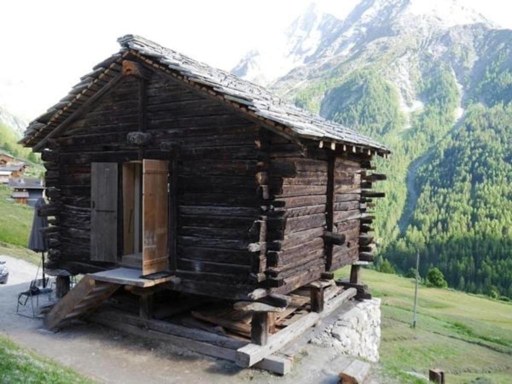 uma pequena cabana de madeira ao lado de uma montanha em Mayen à Henri em Haudères