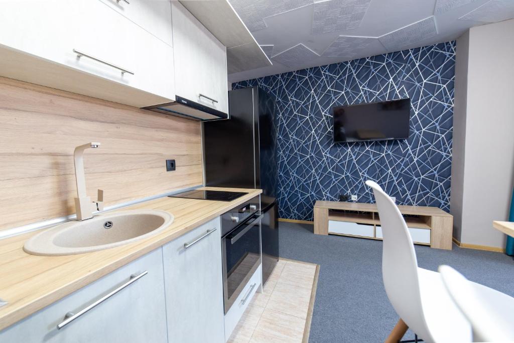 a kitchen with a sink and a tv on a wall at Luxury Studio Apartment - Varna Residens in Varna City