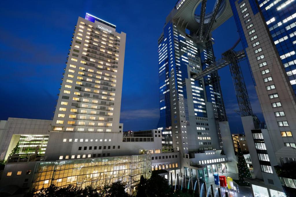 two tall buildings in a city at night at The Westin Osaka in Osaka