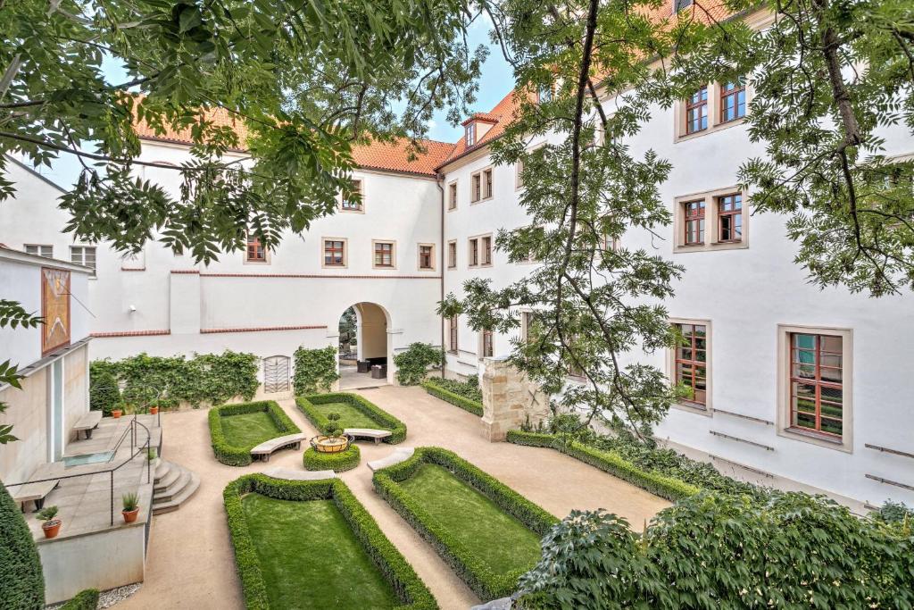 einen Blick nach außen auf ein Gebäude mit Garten in der Unterkunft Augustine, a Luxury Collection Hotel, Prague in Prag