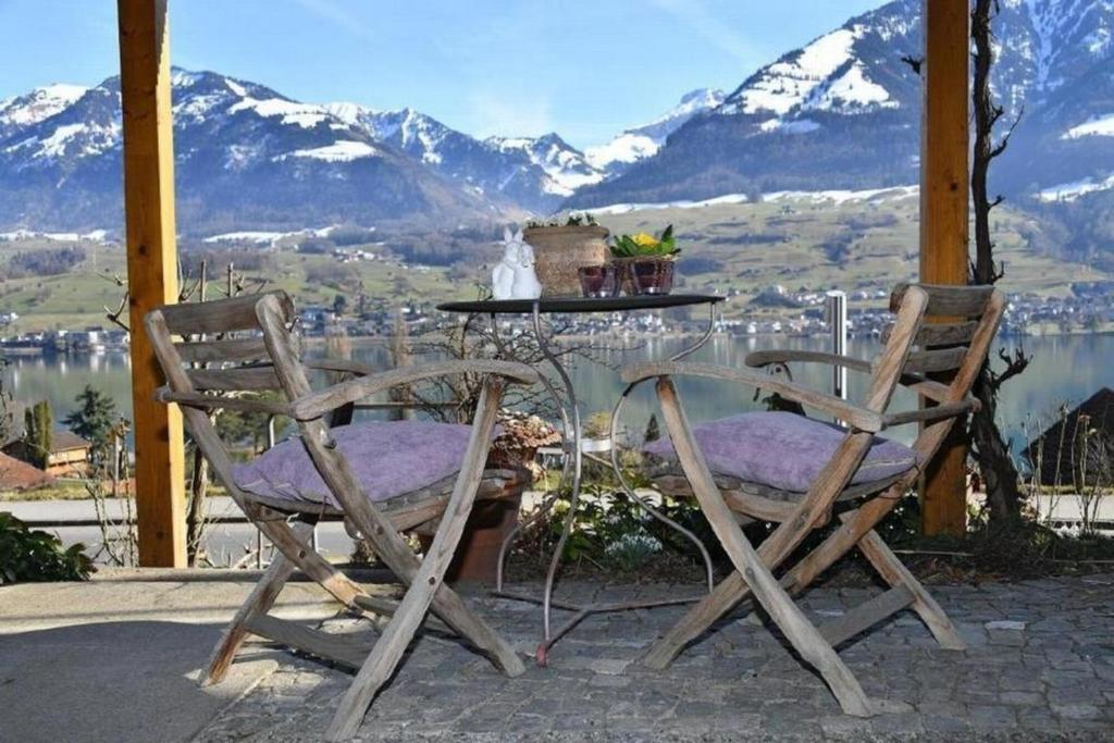 two chairs and a table with a view of mountains at Seeblick - a78060 in Stalden