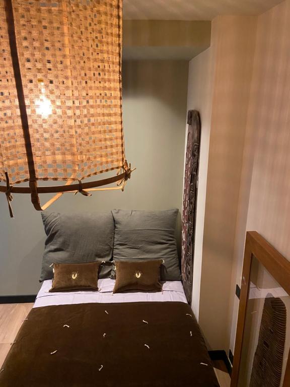 Bett in einem Zimmer mit zwei Kissen darauf in der Unterkunft La Suite TAMAN au centre de Salon in Salon-de-Provence