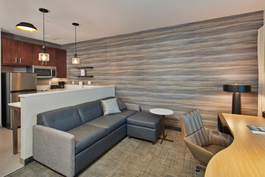 uma sala de estar com um sofá e uma cozinha em Residence Inn Sacramento Davis em Davis