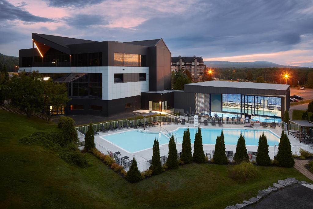 布佩的住宿－Delta Hotels by Marriott Mont Sainte-Anne, Resort & Convention Center，一座大型建筑,前面设有一个游泳池