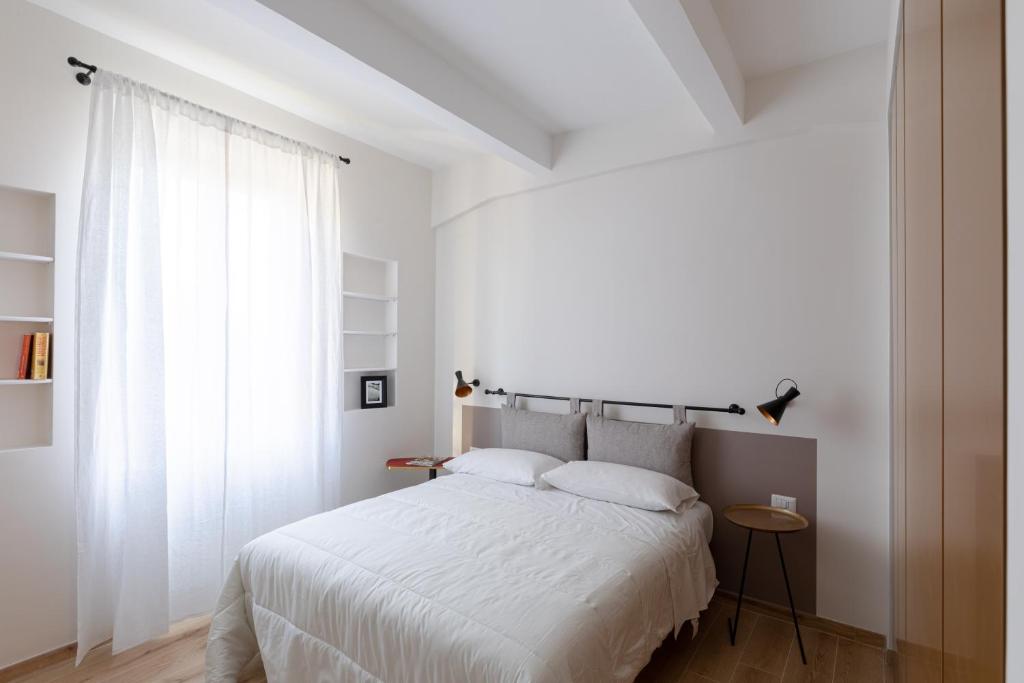 a bedroom with a white bed and a window at Olimpico Apartment - Zen Real Estate in Rome