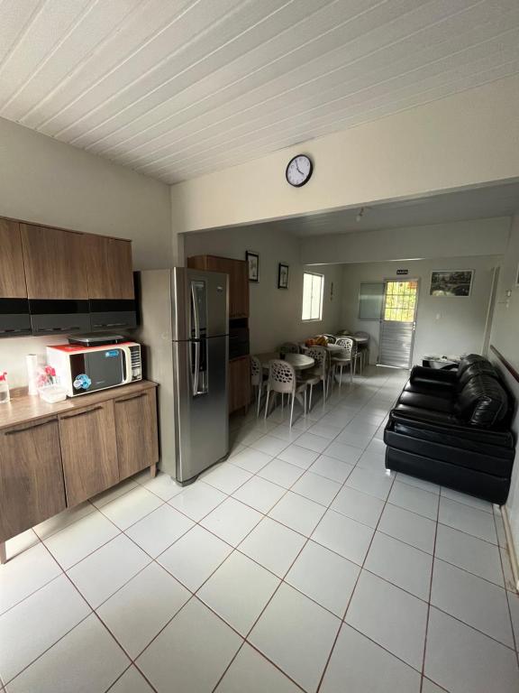 cocina y sala de estar con sofá y nevera en Casa do Anjo, en Fernando de Noronha