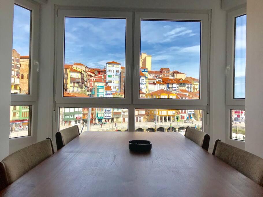 een tafel in een kamer met uitzicht op de stad bij Antigua Casa Pescadores Vista Panorámica in Bermeo