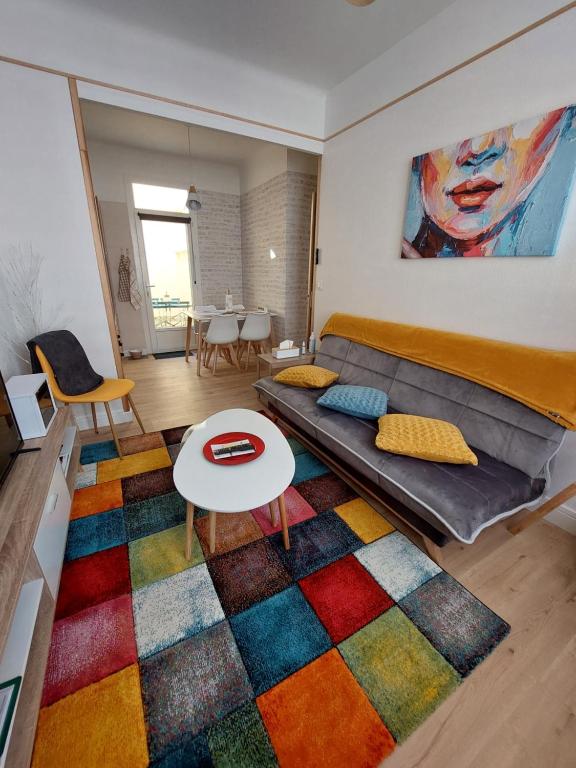 a living room with a couch and a colorful rug at L'Appartement Gabriel T2 in Bergerac