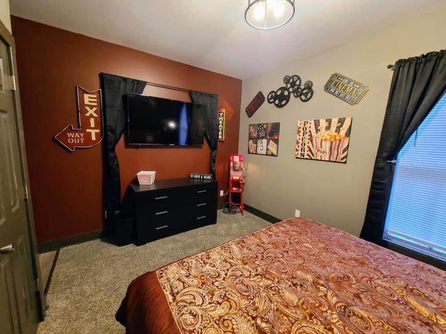 a bedroom with a bed and a flat screen tv at King Bed In Main Floor - Downtown Vacation Rental in Kalamazoo