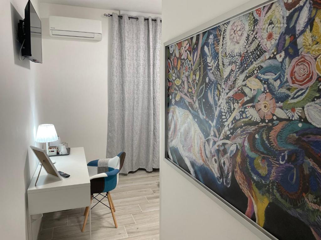 Cette chambre dispose d'un bureau et d'une peinture murale. dans l'établissement Casa da Lory, à Foggia