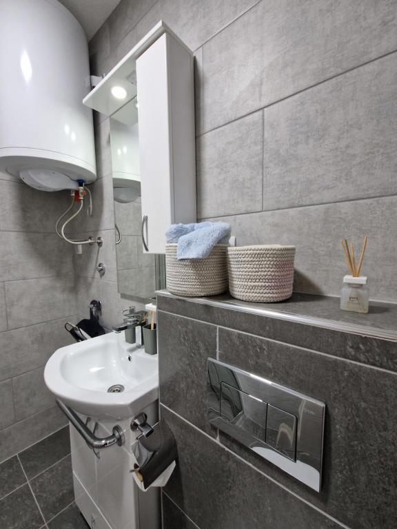 ein Bad mit einem Waschbecken und einem Spiegel in der Unterkunft Apartments Gradiska in Bosanska Gradiška