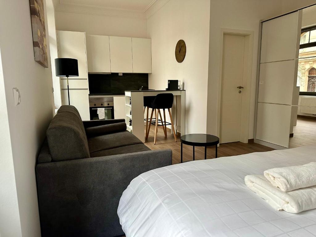 ein Schlafzimmer mit einem Bett und einem Sofa sowie eine Küche in der Unterkunft IMMOBILIARE Lux Tram in Luxemburg (Stadt)