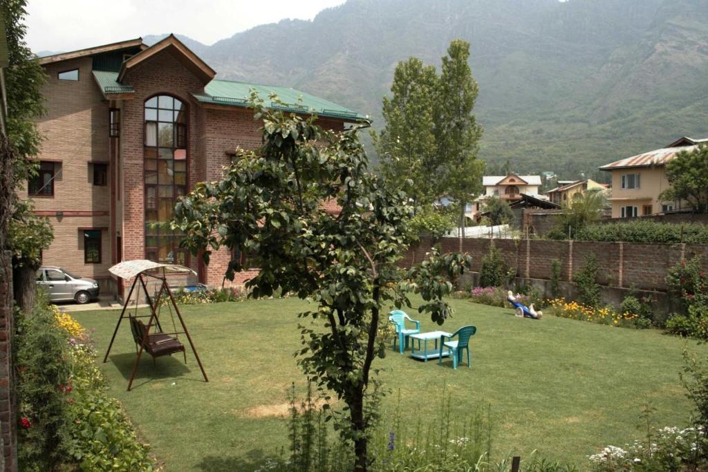 una casa con un patio con un columpio en Sheesha Residency en Srinagar