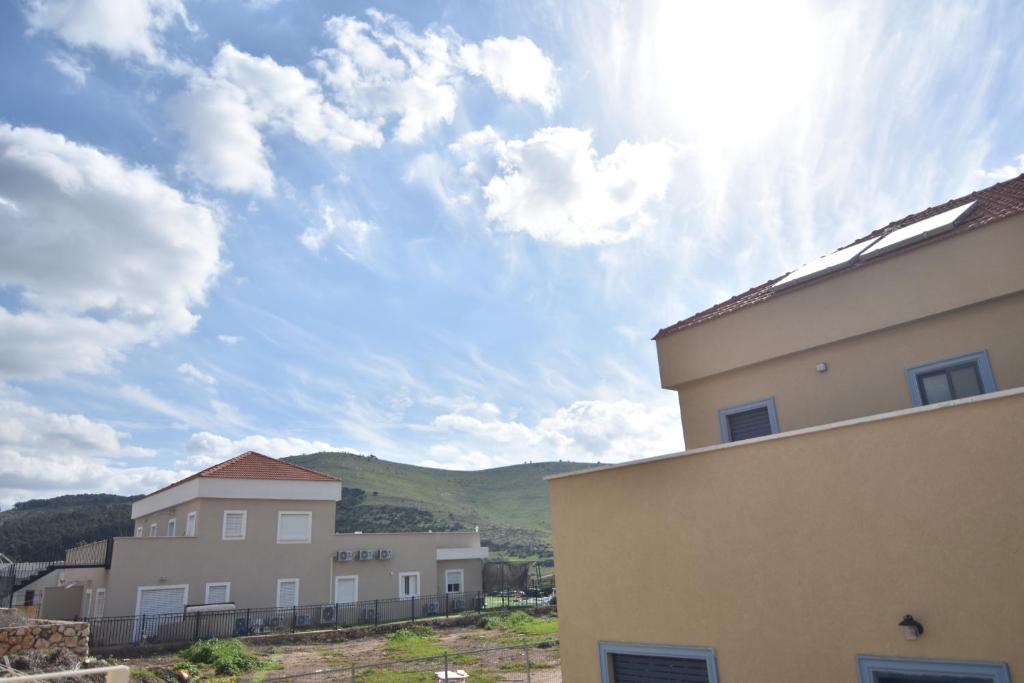 una vista de algunos edificios y un cielo con nubes en יפעת הגלבוע -צימר משפחתי וזוגי מפנק בגלבוע, en Nurit