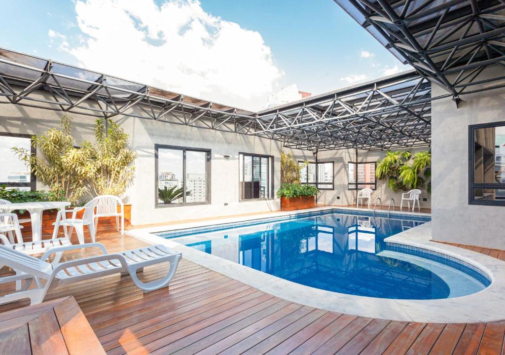 una piscina en una casa con terraza y patio en Consolação by Charlie, en São Paulo