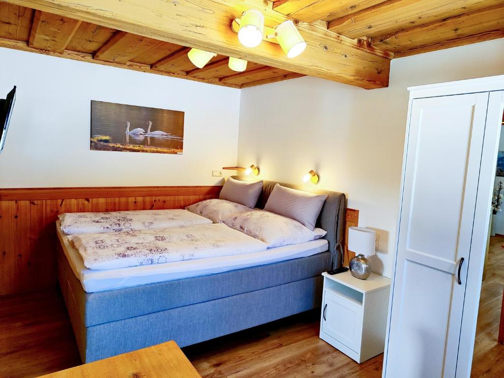 ein Schlafzimmer mit einem Bett in einem Zimmer mit Holzdecken in der Unterkunft Ferienwohnung Grundlsee, Willkommen in MaMi's Ferienwohnung in Grundlsee