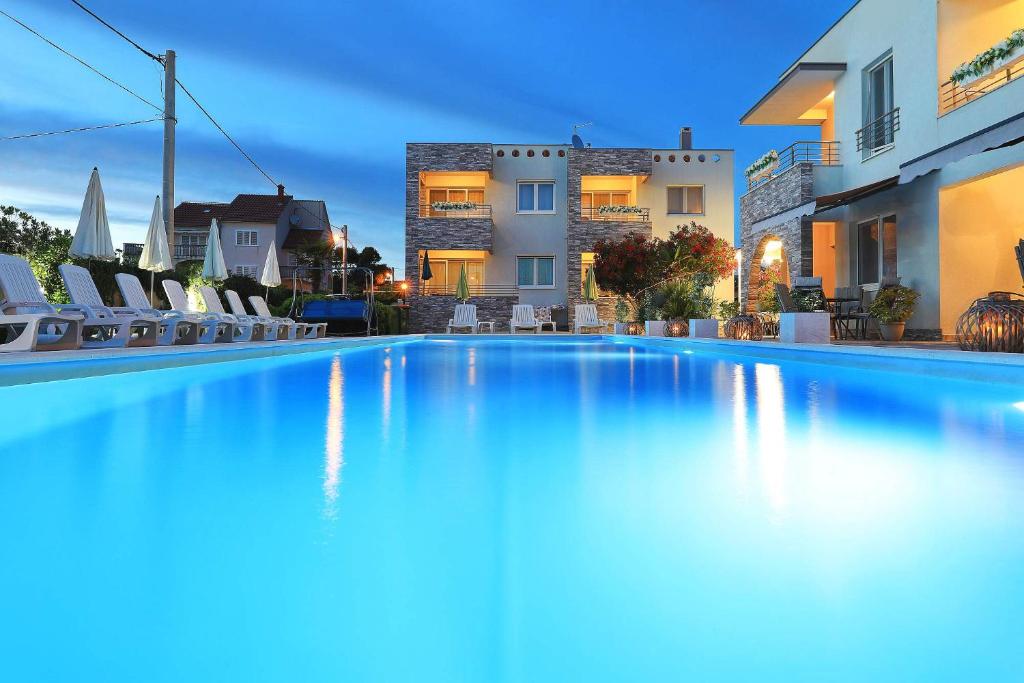 a large swimming pool in front of a building at Apartments Punta in Privlaka