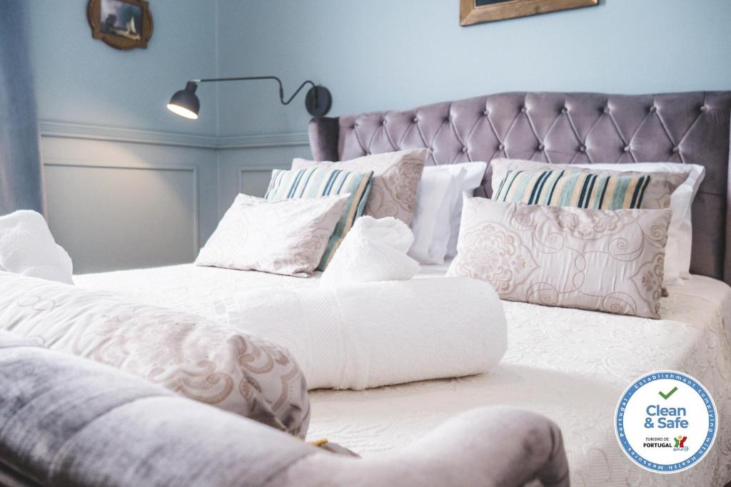 een slaapkamer met 2 bedden met witte lakens en kussens bij Casa do Vereador in Ponta Delgada