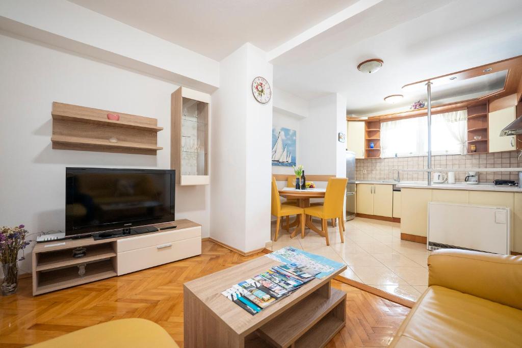 uma sala de estar com uma televisão e uma mesa em Apartment Suzy em Zadar