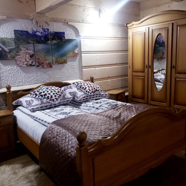 a bedroom with a bed with pillows and a cabinet at U Huraja in Groń