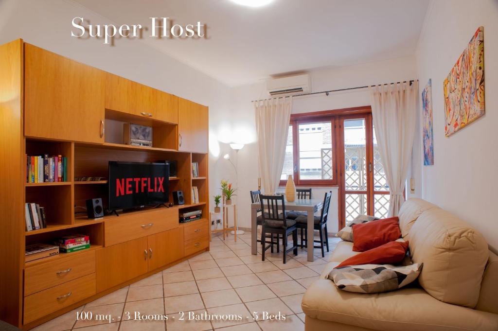 ein Wohnzimmer mit einem Sofa, einem TV und einem Tisch in der Unterkunft Apartment Il Tettuccio di Valerio in Rom