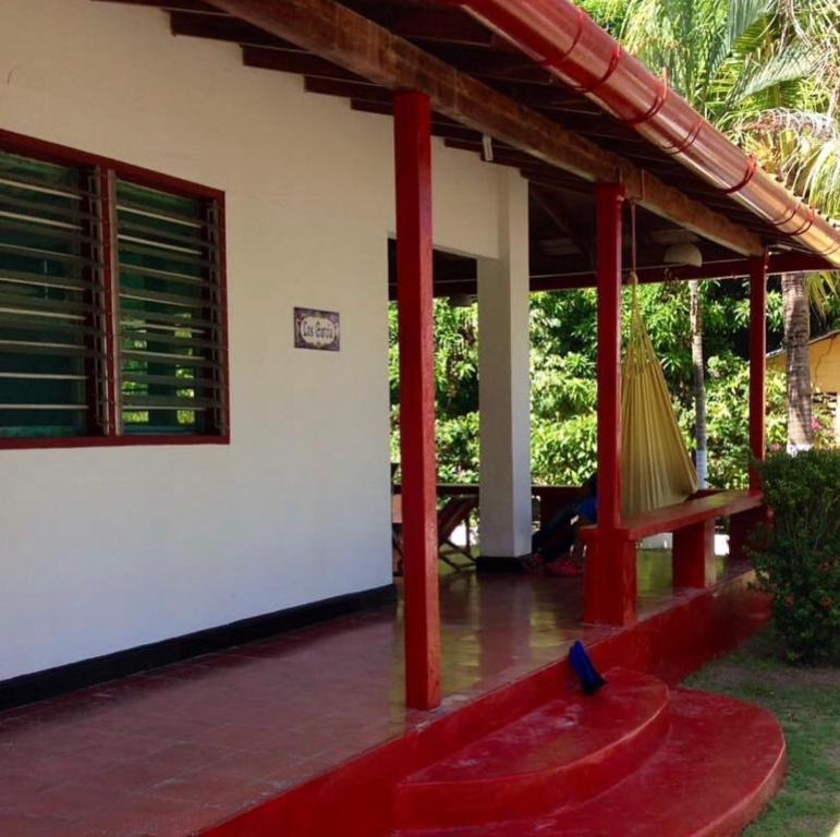 eine Veranda eines Hauses mit einer Hängematte darauf in der Unterkunft Cabaña Coveñas Los García in Coveñas