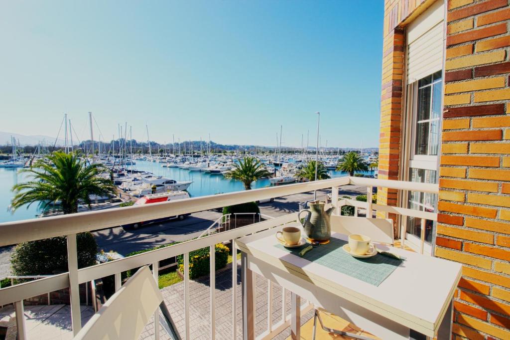 balcón con mesa y vistas al puerto deportivo en El Rincón del Puerto, en Santander