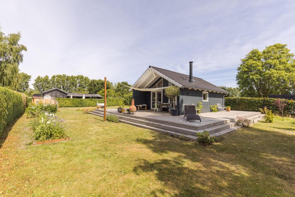 une petite maison avec une terrasse dans une cour dans l'établissement Modern and cozy cabin near Copenhagen city and airport, à Dragør