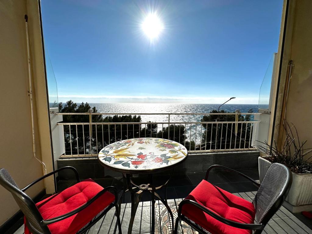 a balcony with a table and chairs and a view of the ocean at Suite Fronte Mare - Sanremo in Sanremo