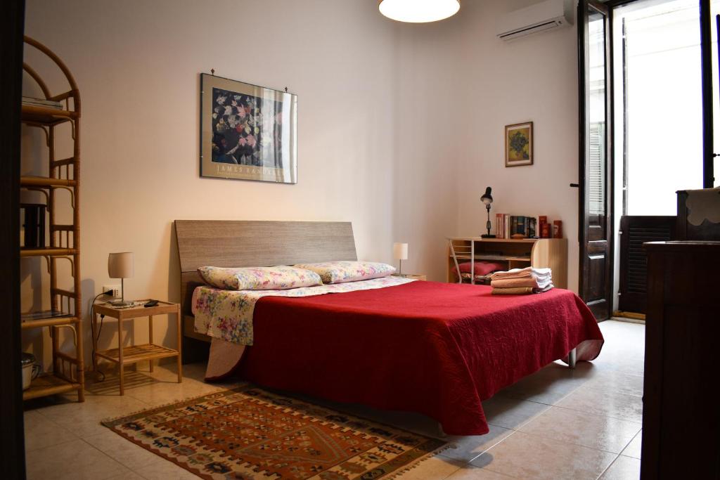 een slaapkamer met een bed met een rode deken bij La Terrazza sul Tempio in Brindisi