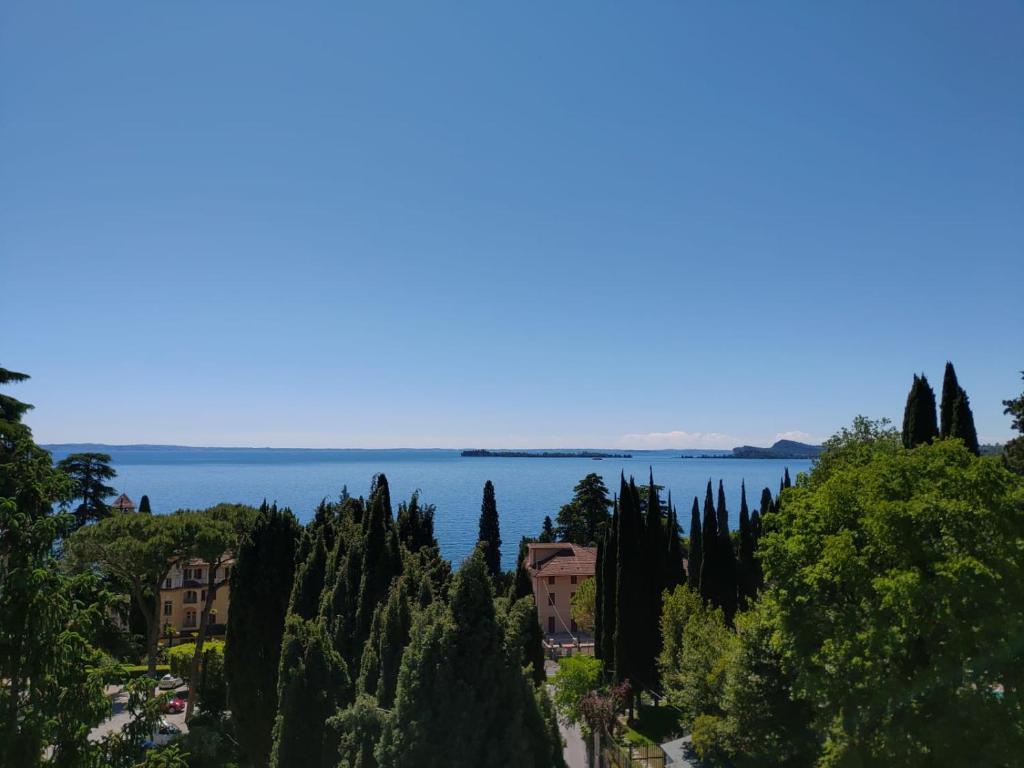 a view of the lake from a hill with trees and houses at House Of Music in Gardone Riviera