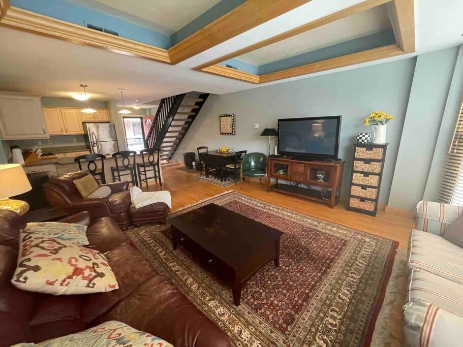 a living room with a couch and a television at Luxury Downtown Living In Armory Square in Syracuse