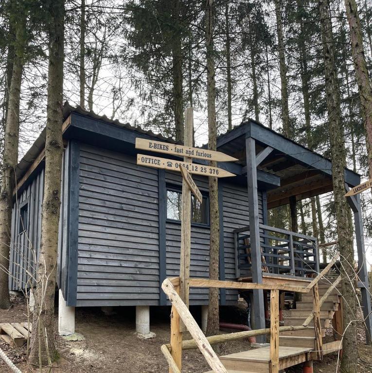 eine blaue Hütte mitten im Wald in der Unterkunft Waldhütte Fuchsbau in Fürstenfeld