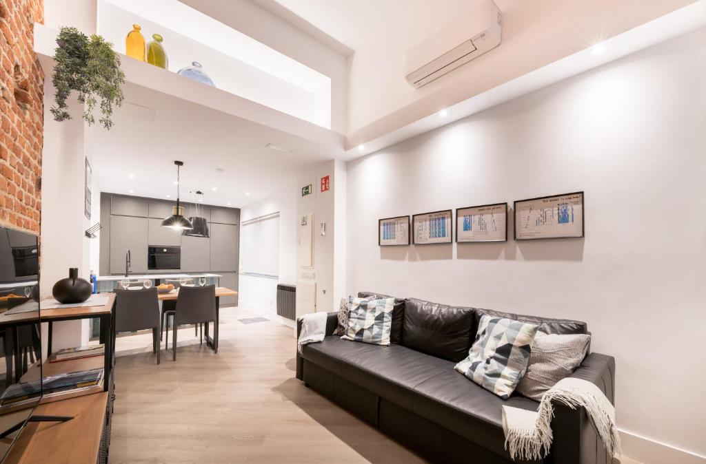 een woonkamer met een bank en een eetkamer bij Loft Retiro in Madrid