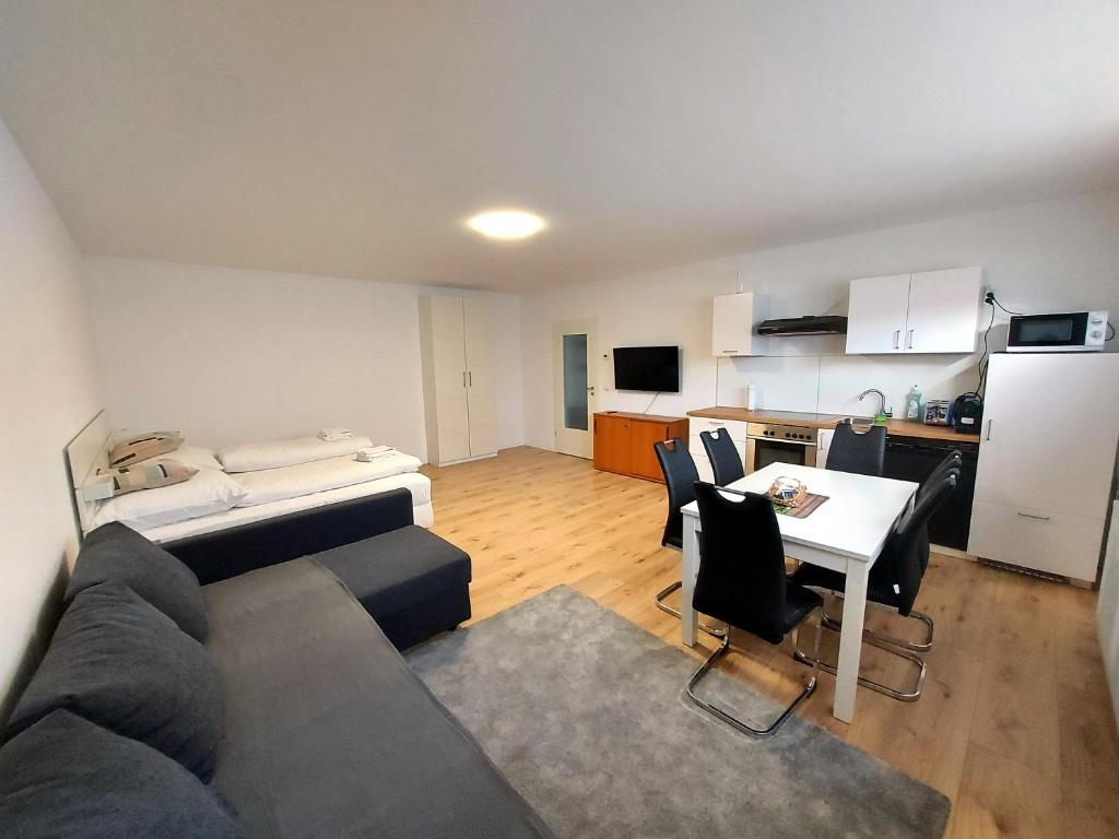 a living room with a couch and a table and a kitchen at Apartments im Taunus in Neu-Anspach