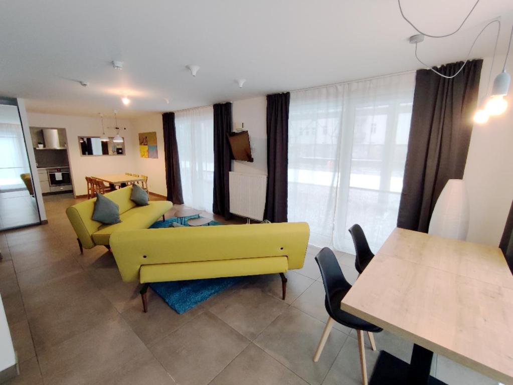 a living room with a yellow couch and a table at Spreepolis Boardinghaus in Berlin