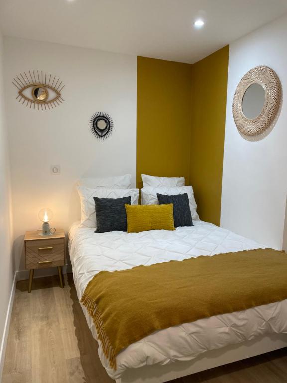 - une chambre avec un grand lit aux murs jaunes dans l'établissement Superbe Studio Meublé - Houdan, à Houdan