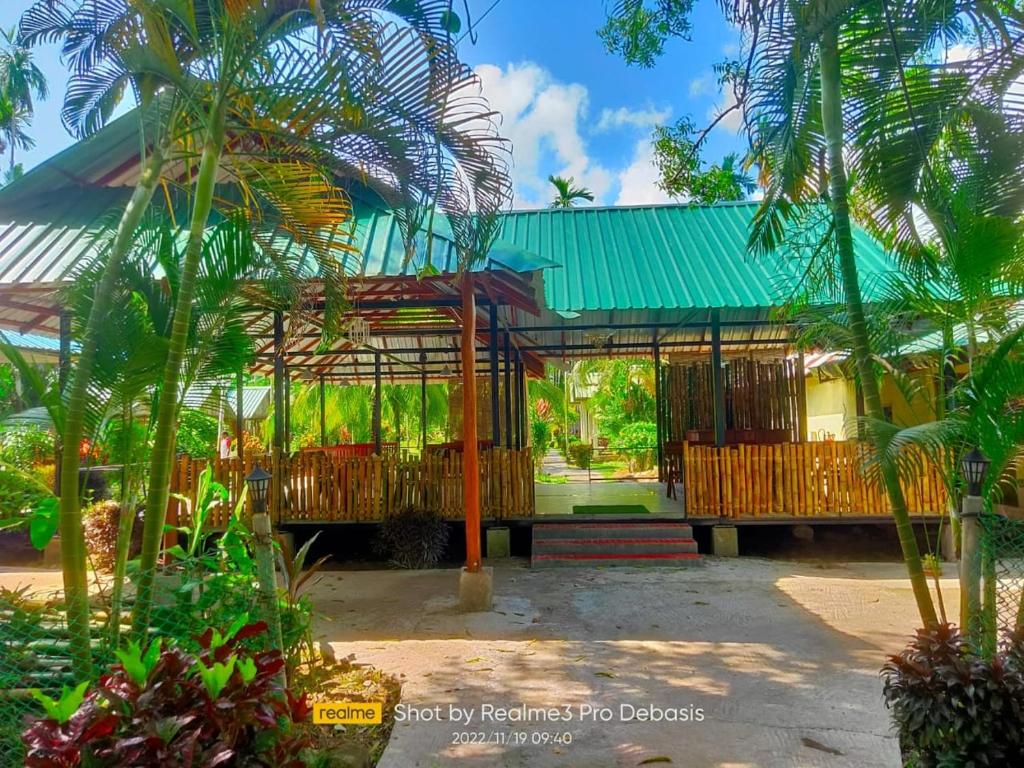 uma casa com um telhado verde e algumas palmeiras em Green Imperial em Port Blair