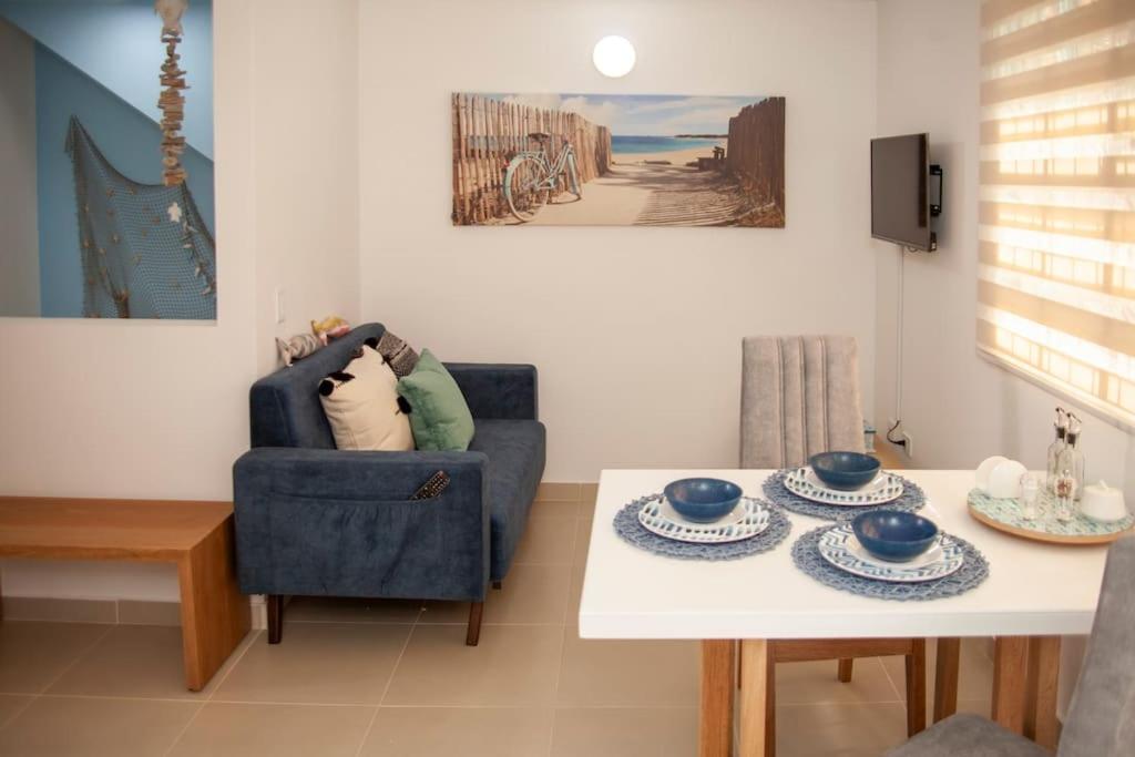 ein Wohnzimmer mit einem blauen Stuhl und einem Tisch in der Unterkunft Duplex Familiar Apartment Aqua in Guatapé