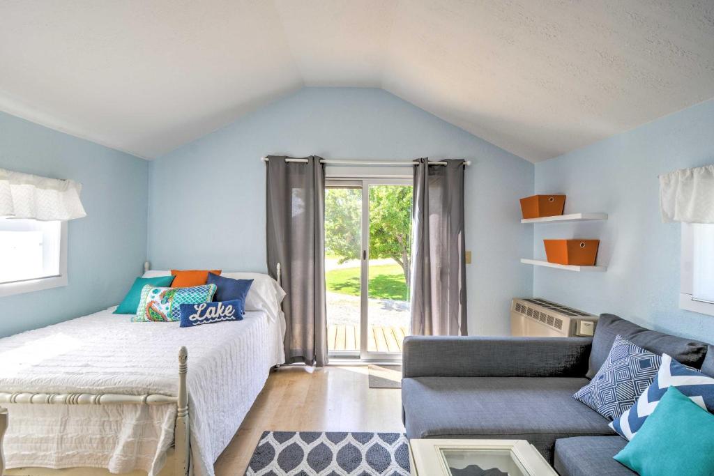 - une chambre avec des murs bleus, un lit et un canapé dans l'établissement Charming Tiny Cottage with Boat Dock on Crooked Lake, 