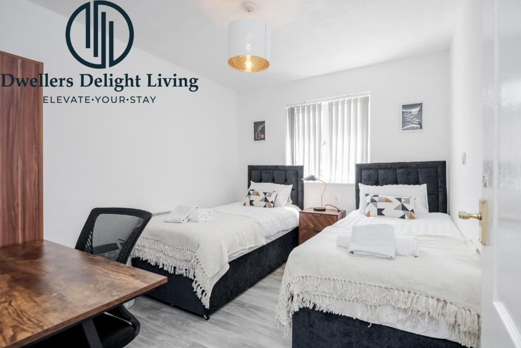 two beds in a room with a desk and a table at Dwellers Delight Living Ltd Serviced Accommodation Charming 3 Bedroom Flat, Chafford Hundred, Grays with Free Parking & Wifi in West Thurrock