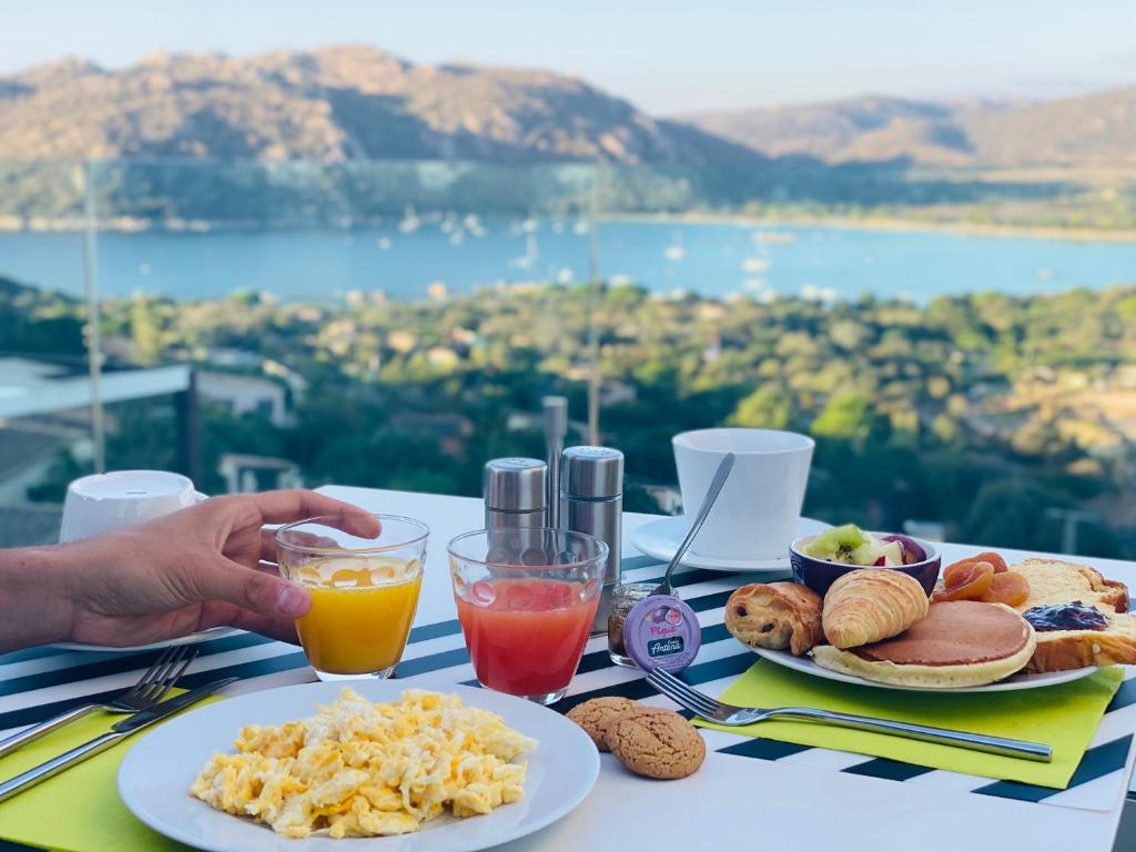 - une table avec des assiettes de nourriture et de boissons dans l'établissement Hotel Carre Noir, à Porto-Vecchio