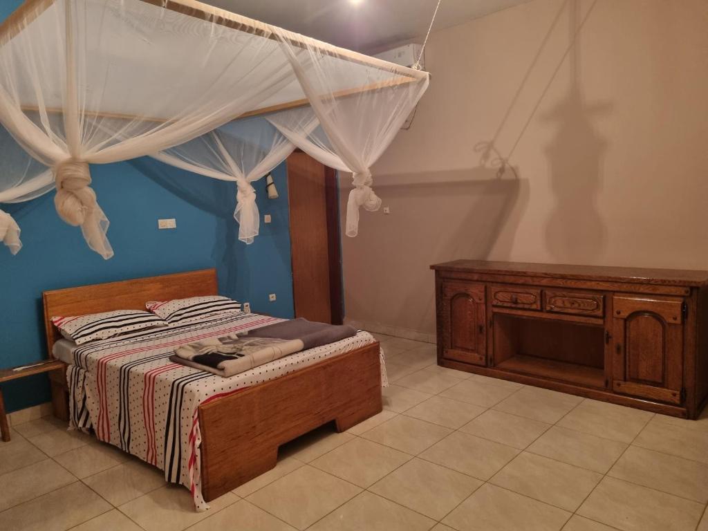 ein Schlafzimmer mit einem Himmelbett und einer Kommode in der Unterkunft AUBERGE LA PRALINE 