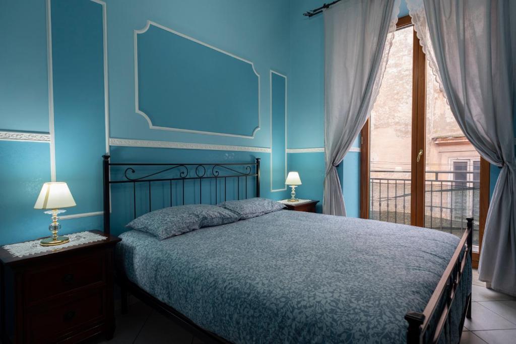 a blue bedroom with a bed and a window at SpaccaNapoli Home in Naples