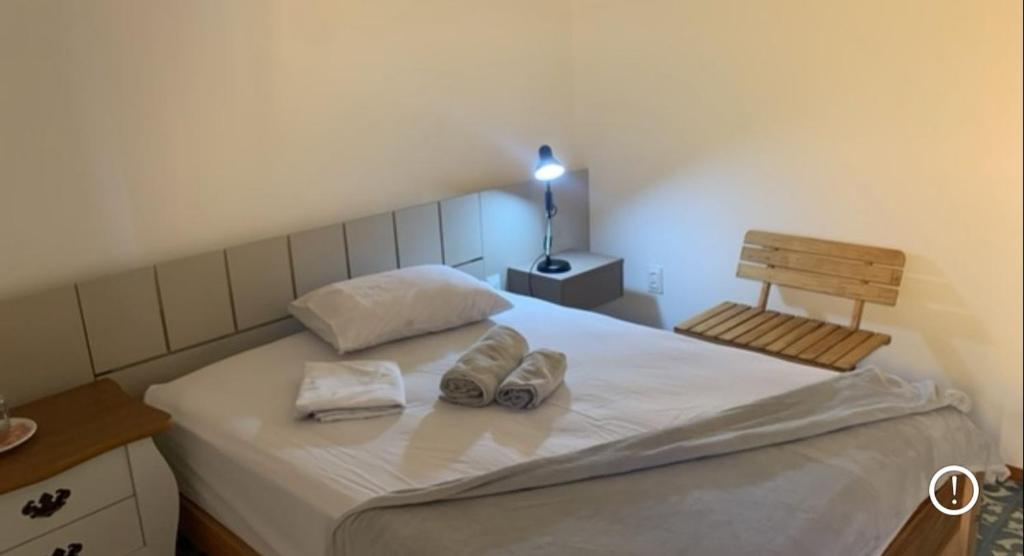 a bedroom with a bed with two pairs of shoes on it at Casarão 47 in Areia