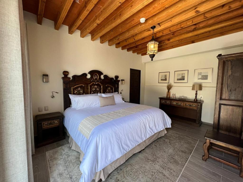 um quarto com uma cama grande e um tecto de madeira em Hotel Boutique Rincón de Luna em San Juan del Río