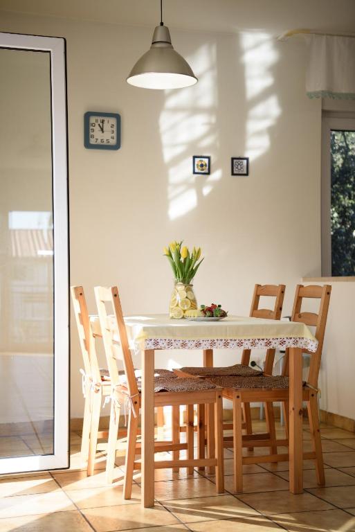 a dining room table with chairs and a vase of flowers at Villa Claudia Lemon Appartment in Premantura